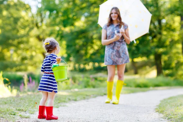 Mãe e pouco adorável criança menina filha em botas de chuva — Fotografia de Stock