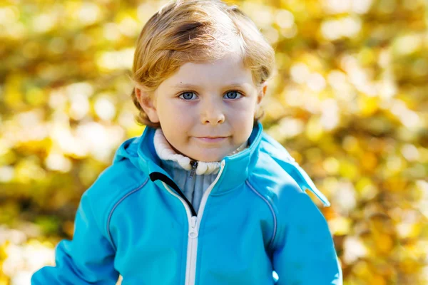 Mały chłopiec dziecko z żółty jesienny liść w parku — Zdjęcie stockowe