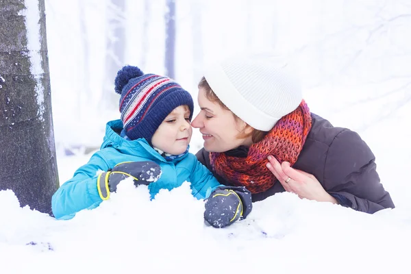 Mãe feliz e seu filho menino se divertindo com neve no inverno — Fotografia de Stock