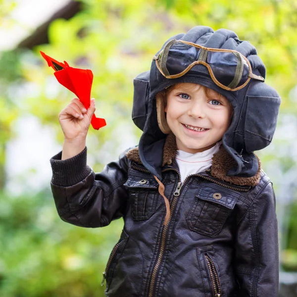 Criança feliz no capacete piloto brincando com avião de brinquedo — Fotografia de Stock