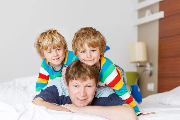 Two little sibling kid boys and dad having fun in bed after slee — Stock Photo, Image