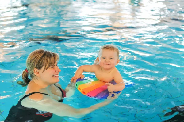 Little baby boy and his mother learning to swim in an indoor swi — Stock Photo, Image