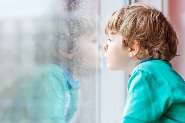 pencere oturan ve üzerinde yağmur damlası arıyorsunuz küçük sarışın çocuk çocuk
