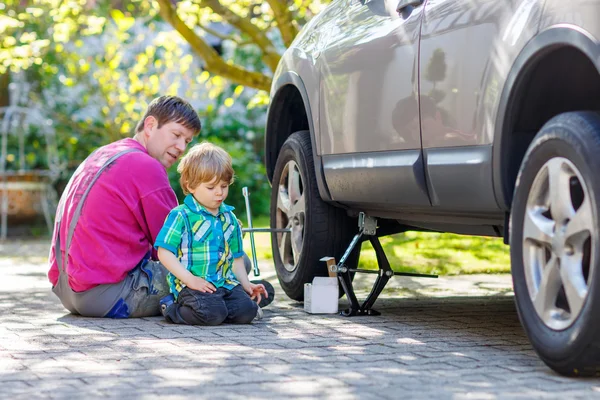 Gelukkig vader en zijn kleine peuter jongen repareren van auto en changi — Stockfoto