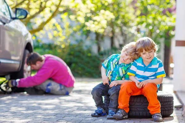 Father and two little  kid boys repairing car and changing wheel — Stock Photo, Image