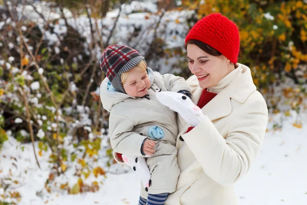 Kar kış gününde eğleniyor anne ve yürümeye başlayan çocuk — Stok fotoğraf