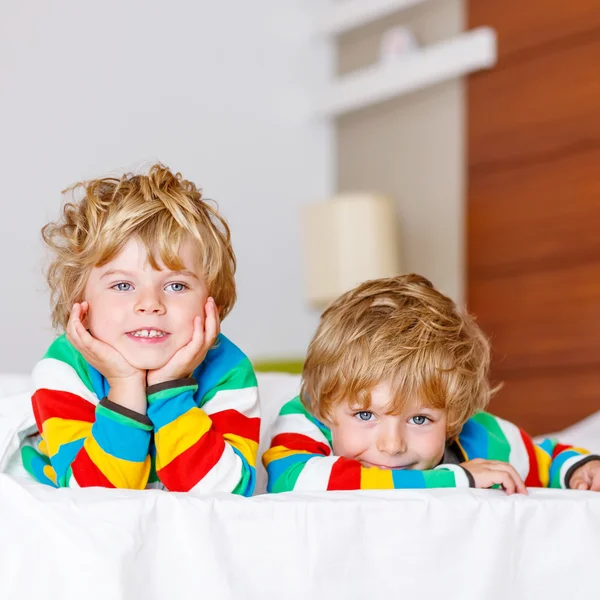 Dos niños hermanos divirtiéndose en la cama después de dormir —  Fotos de Stock