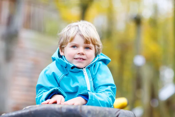 Liten unge pojke att ha kul på hösten lekplats — Stockfoto