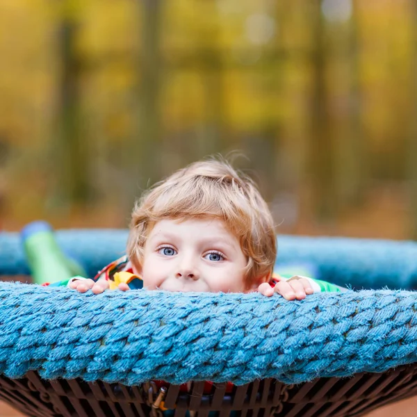 Liten unge pojke att ha kul på hösten lekplats — Stockfoto