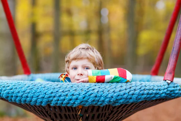 Petit garçon s'amuser sur l'aire de jeux d'automne — Photo