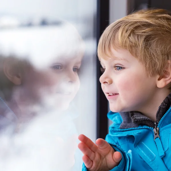 Vackra barn pojke tittar ut tågfönstret utanför och trave — Stockfoto