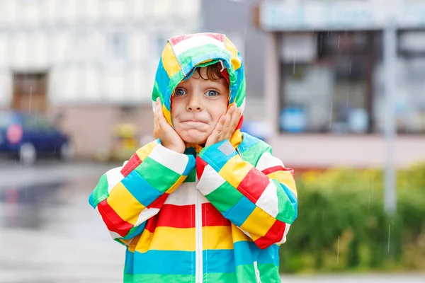 Divertente sorridente ragazzino che cammina in città attraverso la pioggia — Foto Stock