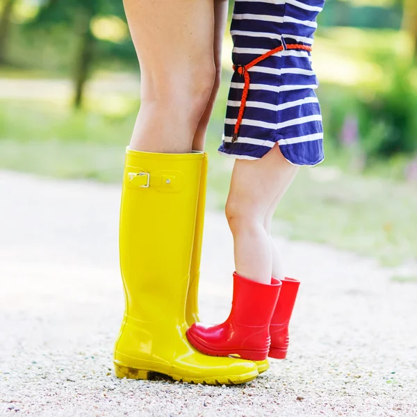 Madre y niña adorable en botas de goma que se divierten —  Fotos de Stock