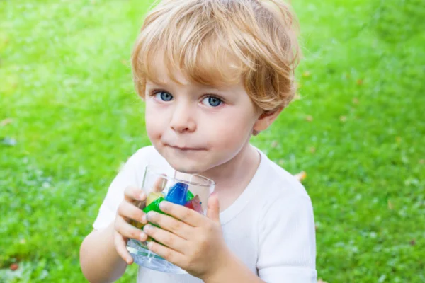 Beautiful toddler boy with glass of berry ice cubes — Stock Photo, Image