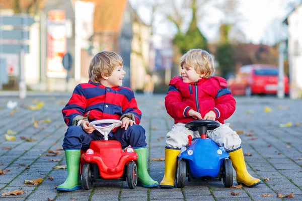 Dois amigos felizes meninos brincando com o carro de brinquedo velho grande, ao ar livre — Fotografia de Stock