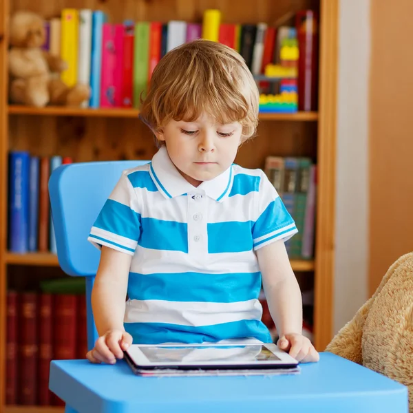 Liten unge pojke leker med tablett dator i sitt rum hemma — Stockfoto