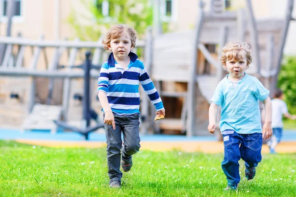 Dos niños hermanos jugando juntos en un patio de recreo, ou —  Fotos de Stock