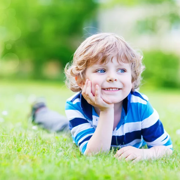 Enfant heureux jouissant sur le champ d'herbe et rêvant — Photo