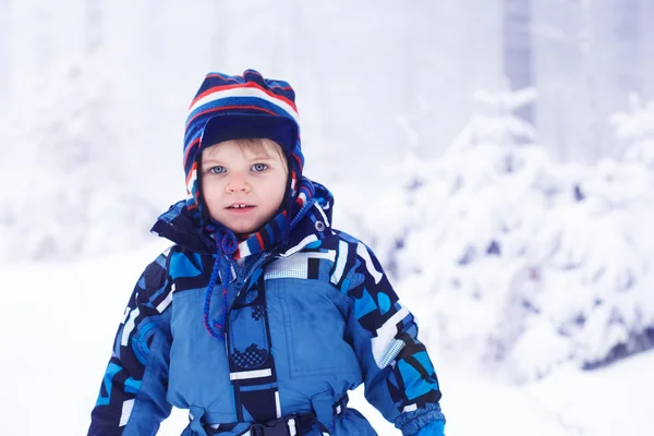 Menino pequeno se divertindo com neve ao ar livre na bela wi — Fotografia de Stock