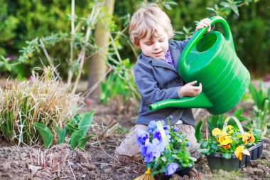 Little boy gardening and planting flowers in garden clipart