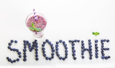 Blueberry smoothie bir cam kavanoza bir saman ve ince dal nane