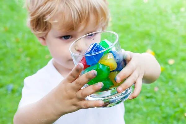 Beautiful toddler boy with glass of berry ice cubes — Stock Photo, Image