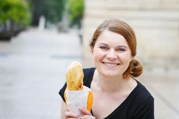 Jeune femme avec baguette fraîche dans la rue d'une ville en France . — Photo