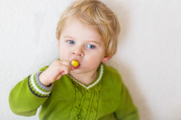 Little happy toddler boy eating lollipop — Stock Photo, Image
