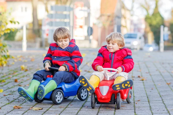 Två glada vänner pojkar leker med färgglad leksaksbil, utomhus — Stockfoto