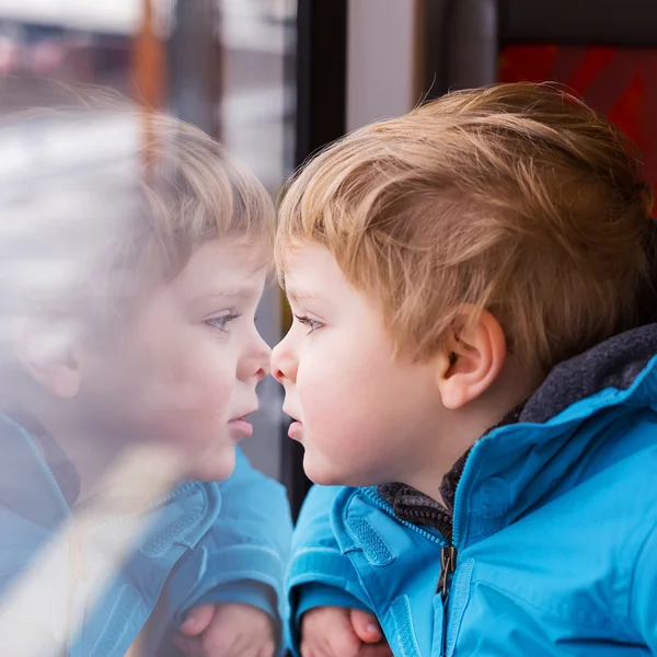Cute child traveling and looking out train window outside — Stock Photo, Image