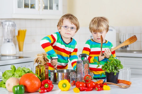 Два милых маленьких братишки готовят итальянский суп и едят на фритюре — стоковое фото