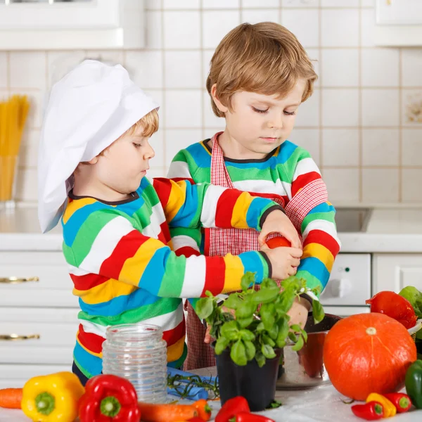 Два забавных маленьких мальчика готовят итальянский суп и еду со свежим V — стоковое фото