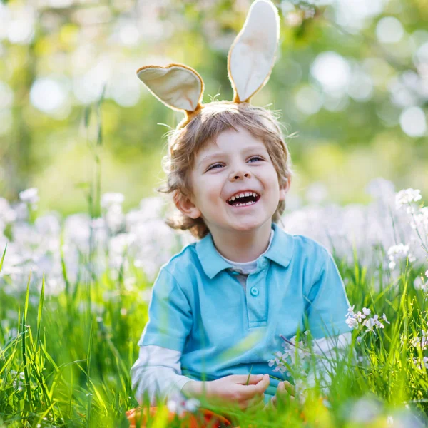 春の緑でイースターのバニーの耳を着てかわいい幸せな男の子 — ストック写真