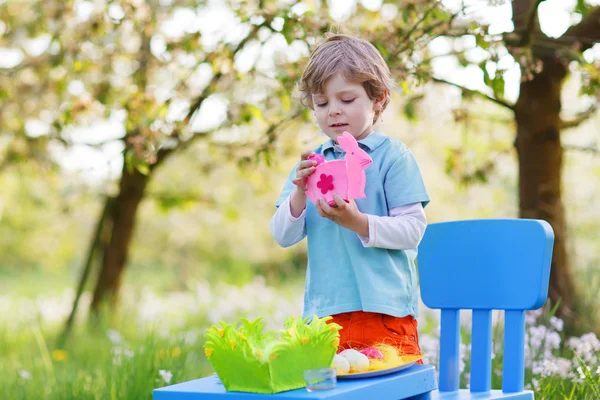 Мальчик играет с разноцветными яйцами — стоковое фото