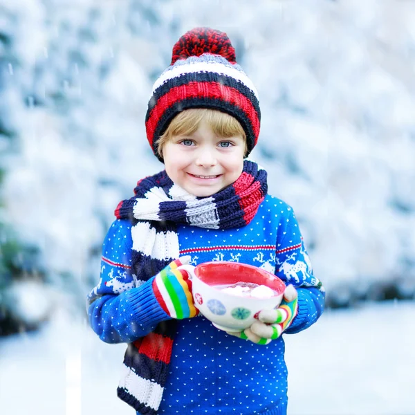 Lustiges kleines Kind mit großer Tasse mit Schneeflocken und heißem Kakao — Stockfoto