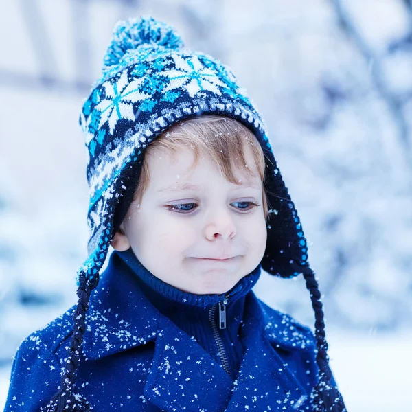 Retrato de niño pequeño en ropa de invierno con nieve cayendo — Foto de Stock