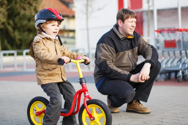 Menino pequeno com bicicleta e seu pai na cidade — Fotografia de Stock
