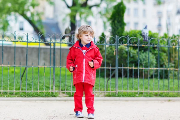 Bonito menino pegando e brincando com pombos na cidade — Fotografia de Stock