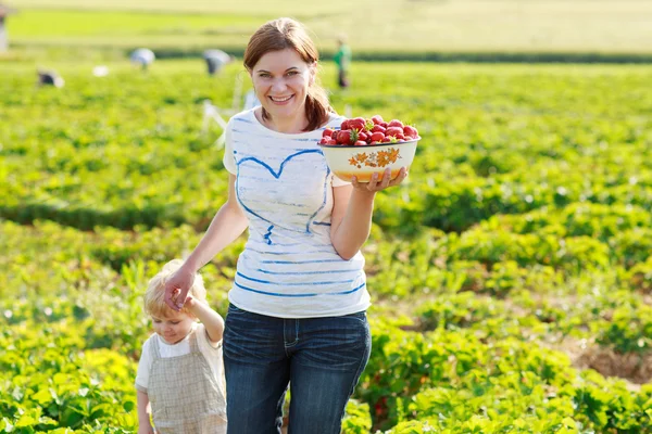 Mutter und ihr kleines Kind auf Bio-Erdbeerfarm — Stockfoto