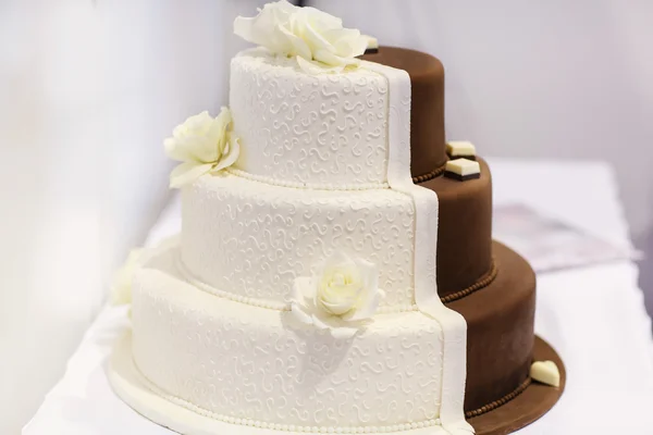 Utsökt vacker bröllopstårta i vitt och brunt. Royaltyfria Stockfoton