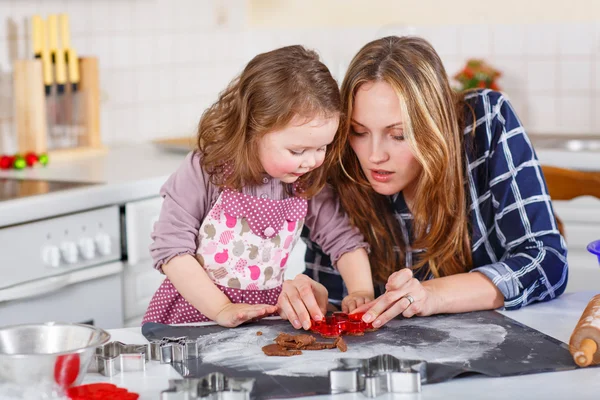 Мать и маленькая девочка пекут пряничное печенье на Рождество — стоковое фото