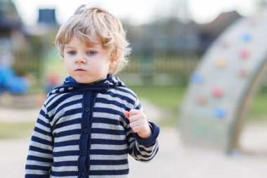 Dışarıdaki çocuk bahçesinde eğlenen küçük çocuğun portresi