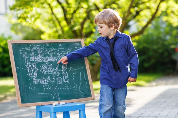 Petit garçon au tableau noir faisant la présentation — Photo