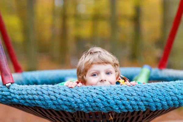 Malý chlapec dítě baví na podzimní dětské hřiště — Stock fotografie