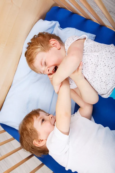 Kleine broer of zus jongens plezier in bed thuis — Stockfoto