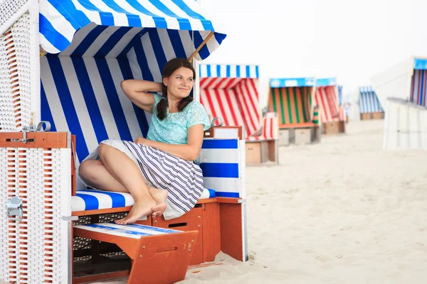 Joven mujer feliz sentado y relajante en la silla de playa en el bea —  Fotos de Stock