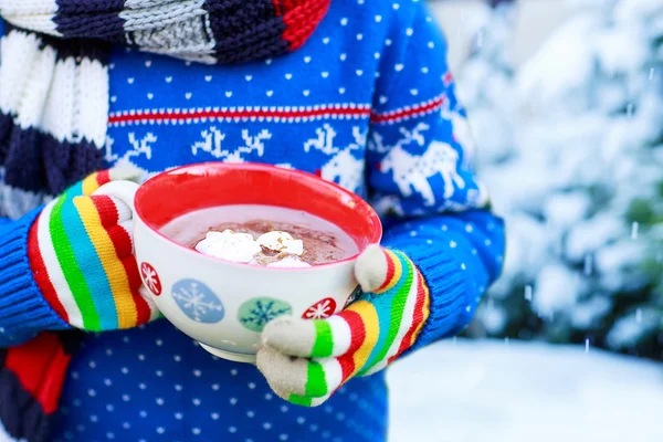 Hands of child holding big cup with snowflakes and hot cocoa and — Stock Photo, Image