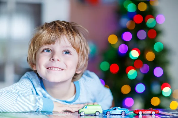 車と自宅のおもちゃで遊んで少しの金髪の子供 — ストック写真