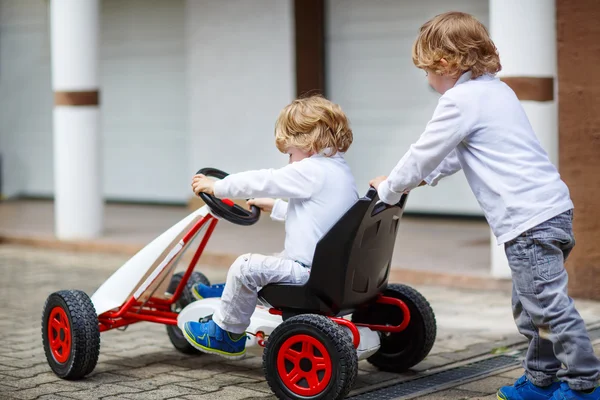 Deux garçons heureux frères et sœurs jouant avec la voiture jouet — Photo