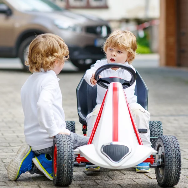 Twee gelukkige broer of zus jongens spelen met speelgoedauto — Stockfoto